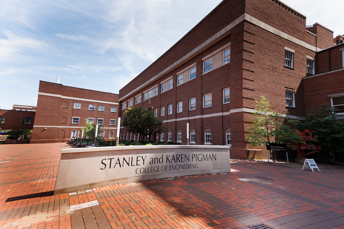 A low stone sign that says "Stanley and Karen Pigman College of Engineering" in a red brick courtyard surrounded by red brick buildings at UK.