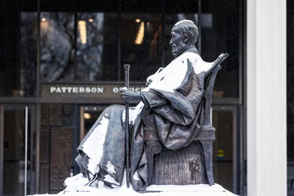 A profile angle of a statue of former UK president James Patterson lightly covered in snow.
