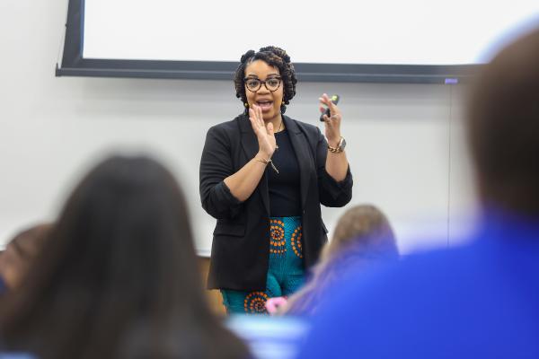Law professor Tiffany Atkins standing in front of a class of students gesturing as she lectures.
