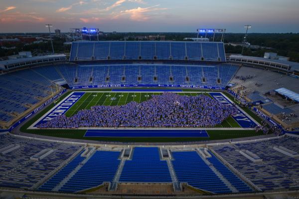 the UK class of 2028 on Kroger Field, grouped in the shape of Kentucky at dusk