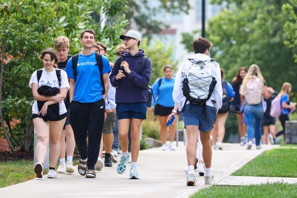 groups of students walking on a sidewalk