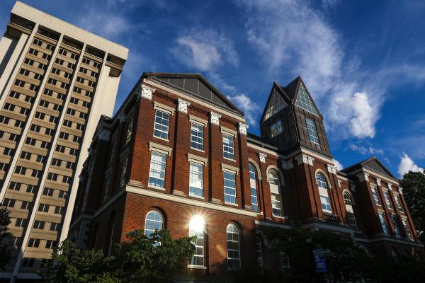 a low-angle view of the Main Building and Patterson Office Tower with blue sky and wispy clouds behind