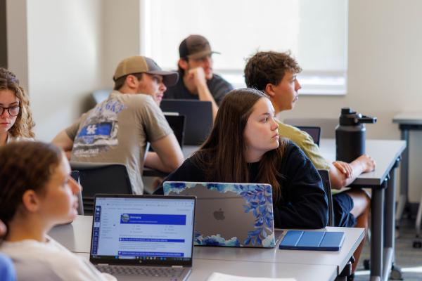 students sitting at tables in class looking at the instructor