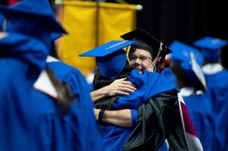 Photo of faculty member hugging student at Commencement