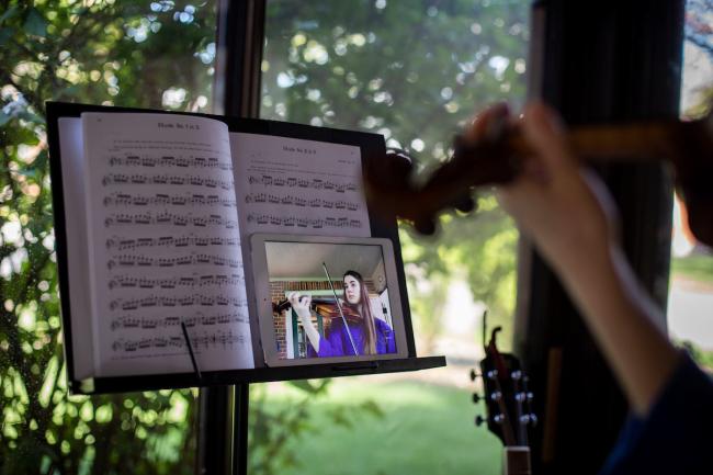 Photo of student taking violin class virtually