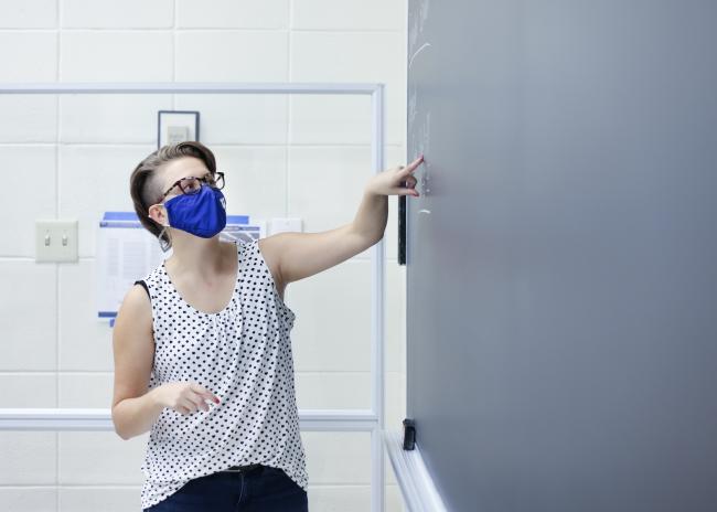 Professor pointing to white board