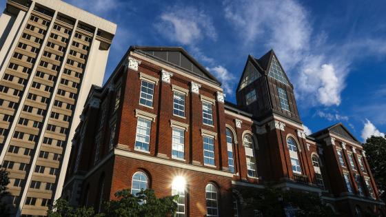 a low-angle view of the Main Building and Patterson Office Tower with blue sky and wispy clouds behind