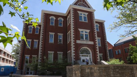 Miller Hall at the University of Kentucky from the front with a man walking up the steps to the door.