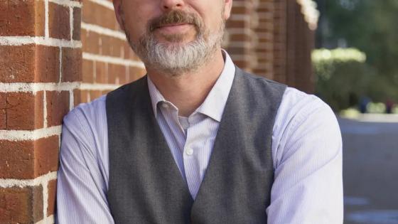Headshot of Eric Weig leaning against a brick building.