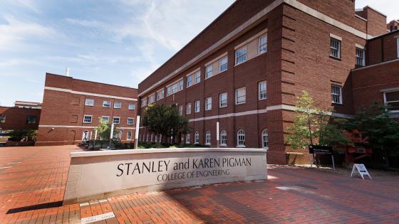 A low stone sign that says "Stanley and Karen Pigman College of Engineering" in a red brick courtyard surrounded by red brick buildings at UK.