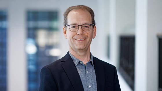 Steve Rankin posing for a headshot wearing a blue button down shirt and dark blue blazer