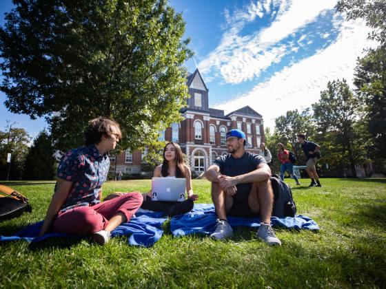 students on grass on campus