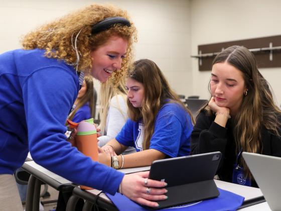 Two students looking at an iPad during class registration at Merit Day