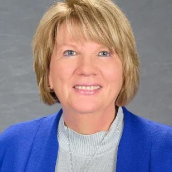 Headshot of Kim Anderson in a blue blazer.