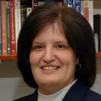 Headshot of Stephanie Bennett in front of bookshelves.