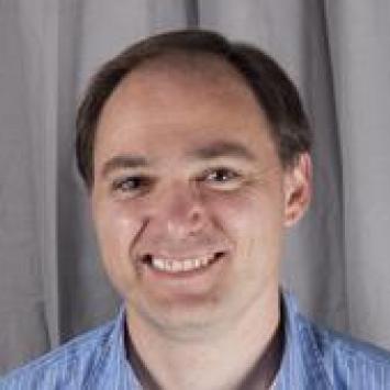 Headshot of Chris Crawford wearing a light blue collared shirt.
