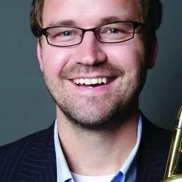 Headshot of Bradley Kerns in a dark jacket and blue button down shirt.