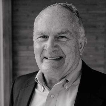 Black and white headshot of Mark O'Bryan in a jacket and collared shirt.