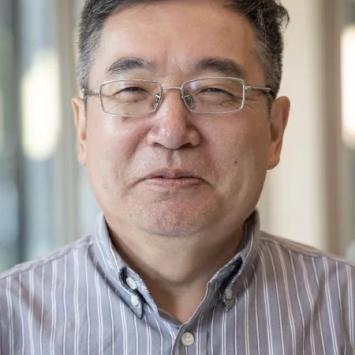 Headshot of Zixue Tai in a striped button-down shirt.
