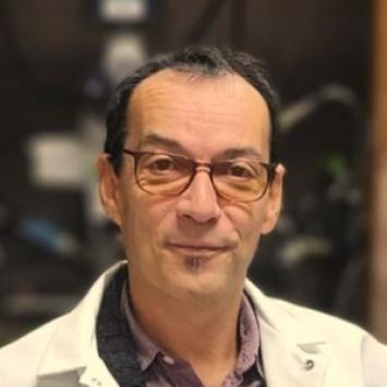 Headshot of Olivier Thibault in a white jacket and collared shirt.