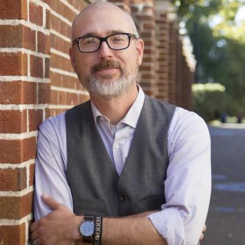 Headshot of Eric Weig leaning against a brick building.