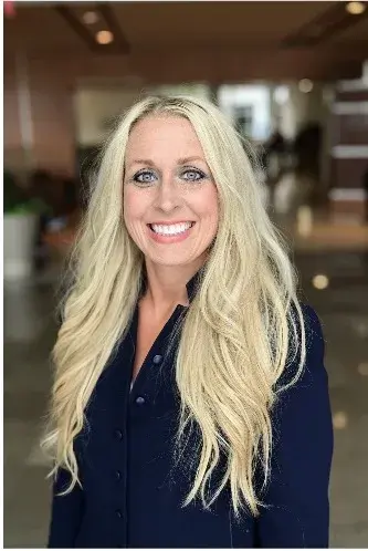 Headshot of woman with long, blonde hair wearing a navy button-up shirt. 