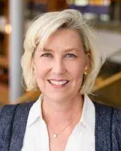 headshot of a woman with blonde hair and a white collared shirt