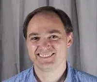 Headshot of Chris Crawford wearing a light blue collared shirt.