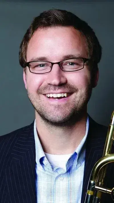 Headshot of Bradley Kerns in a dark jacket and blue button down shirt.