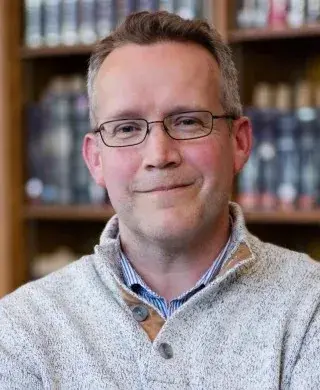 Headshot of Andrew McDonnell in a gray pullover.