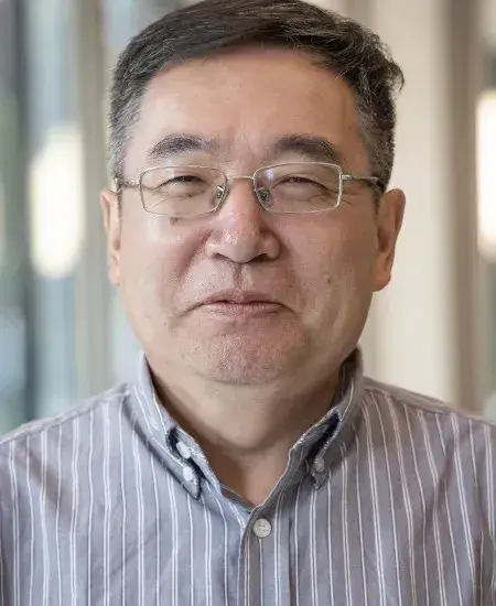 Headshot of Zixue Tai in a striped button-down shirt.